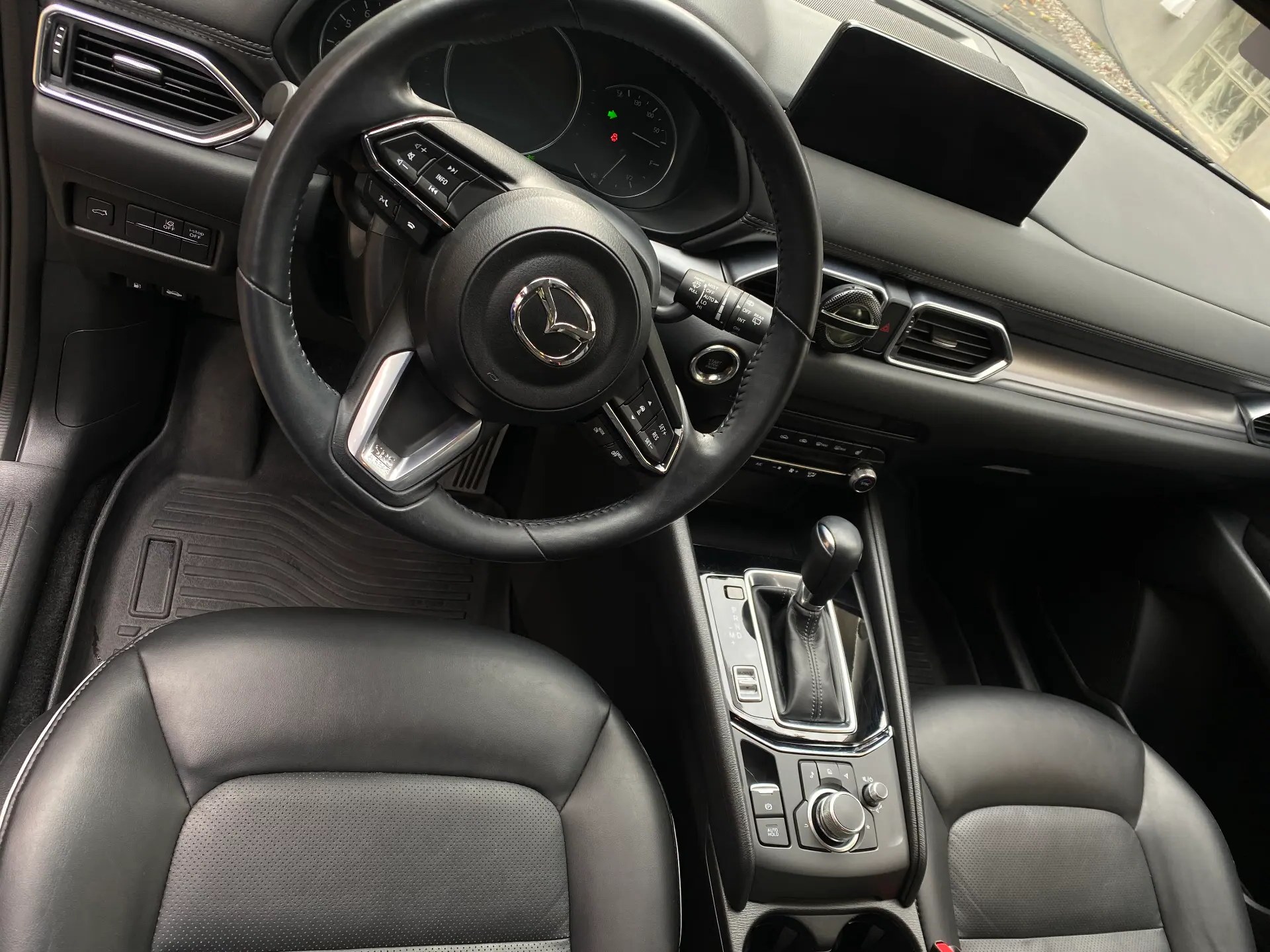 Freshly detailed Mazda interior with clean dashboard, steering wheel and seats